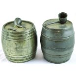 PAIR OF PEWTER TOBACCO JARS. Both barrel shape with pipe shaped finials attached to lid tops, one