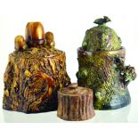 TOBACCO JARS GROUP. Heavy brown glazed tree trunk style stoneware jar with acorns to lid, large