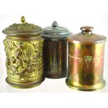 GROUP OF TOBACCO JARS. Brass cylindrical jar with putti figures in relief. Plus copper Viennese