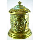 BRASS TOBACCO JAR. 7.75ins tall to top of lid, cylindrical form, frieze all around featuring men &