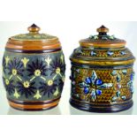 PAIR DOULTON TOBACCO JARS. Cylindrical example with raised floral design. Doulton Lambeth &