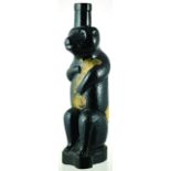 BEAR FIGURAL BOTTLE. 11ins tall, black glass figural in shape of a seated bear, paper label to front