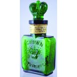 CROWN PERFUMERY LABELLED BOTTLE. 3.3ins tall, green glass, flat rectangular shape, pedestal foot,