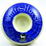 WHITE HORSE WHISKY MATCH STRIKER. 4.25ins diam, donut shaped, matchholder centre & striking area