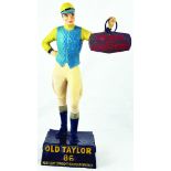 OLD TAYLOR BACK BAR FIGURE. 15ins tall, realistically modelled rubberoid jockey in blue & yellow