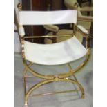 A 20th century cream leather and brass open armchair.