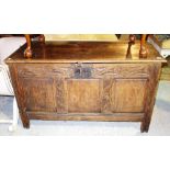 An 18th century oak coffer with triple panel front and later carved decoration, 125cm wide.