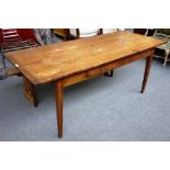 A 19th century French fruitwood kitchen dining table, the plank top on tapering square supports,