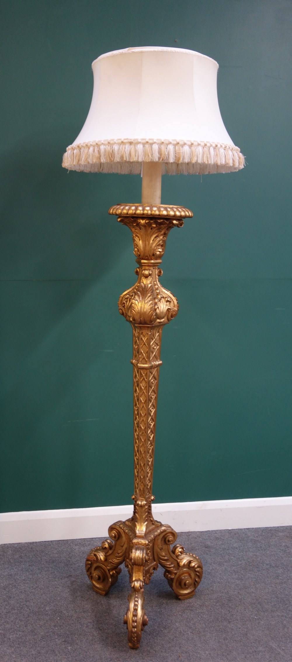 A carved giltwood standard lamp, within blind fret decoration,