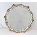 A silver shaped circular salver, with a decorated pie-crust rim, in the Chippendale style,