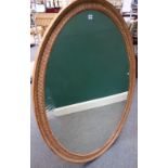 A George III style oval gilt framed mirror with moulded frame, 140cm x 105cm.