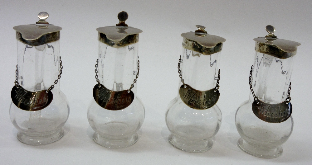 A group of four silver mounted and glass whisky noggins,