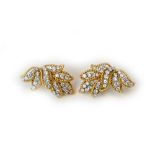 A pair of gold and diamond set earclips, each designed as a foliate spray, with ropetwist borders,