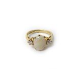 A 9ct gold, opal and diamond three stone ring, claw set with the oval opal at the centre,