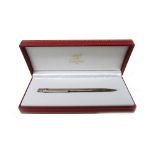 A Must De Cartier silver plated ballpoint pen, with a case, guarantee, two further booklets,