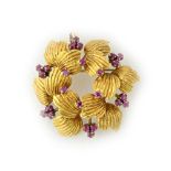 An 18ct gold and ruby set pendant brooch, in a hexagonal stylised wreath design,