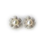 A pair of white gold, diamond and cultured pearl set earclips, each designed as a flowerhead,
