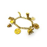 A gold curb link charm bracelet, fitted with nine mostly Oriental gold charms,