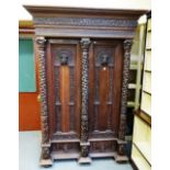 A 19th century carved oak two door wardrobe, with carved column decoration and lower drawers,