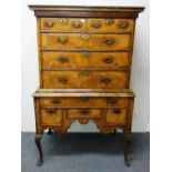 A George I feather banded walnut chest on stand with two short three long drawers,