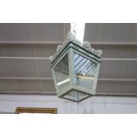A modern green painted metal hall lantern of square tapering form, with a pierced and crested rim,