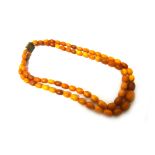 A two row necklace of vary coloured butterscotch coloured graduated oval amber beads,
