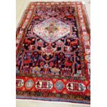 A North West Persian rug, the black field with a pale indigo medallion, angular vines and dogs,