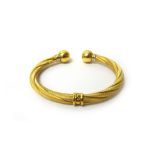 A gold torque bangle, in a decorated twisted design, with plain spherical terminals, detailed 750,