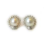 A pair of diamond and mabe pearl set earclips, each mounted with a large mabe pearl at the centre,