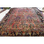 A Sarough carpet, Persian, the madder field, with a stylised medallion, bold leaf and floral sprays,