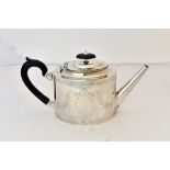 A George III silver teapot, of oval form, with engraved decoration and with later black fittings,