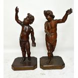 A pair of 18th century German carved wood and gesso life size cherubs on stands, 142cm high.