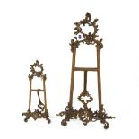 A gilt metal table easel of Rococo design, and another similar, 54cm high (2).