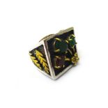 A silver, green and red gem set dress ring, of square form, having a gem set spray motif,