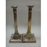 A pair of plated on copper table candlesticks, each in a neo-classical design,
