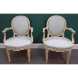 A pair of parcel gilt white painted Louis XVI style fauteuils, 91cm high x 60cm wide.