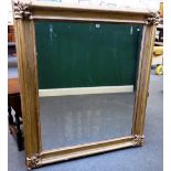 A William IV gilt framed wall mirror, the corners with grotesque masks, 136cm x 159cm.