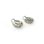 A pair of diamond set two stone earclips, each in a curved design,
