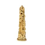 A Japanese ivory okimono, Meiji period, carved with a hawk perched on top of a gnarled tree stump,