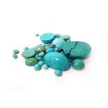 A collection of unmounted gemstones, including emeralds, sunstones, topaz, lapis lazuli, turquoise,