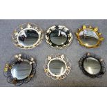 A group of twelve various 20th century convex mirrors, in coloured wrought iron frames,