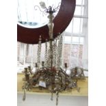 An ormolu twelve light chandelier, early 20th century, with cut crystal festoons and drops, (a.f.