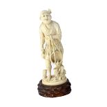 A Japanese ivory okimono of a fisherman, Meiji period, standing carrying a basket in one hand,