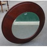 A pair of 20th century leather veneered circular mirrors with swept back frames, 110cm wide.