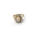 A 9ct gold and opal eleven stone cluster ring, claw set with the oval opal at the centre,