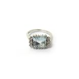A white gold, aquamarine and diamond ring, claw set with the square cut aquamarine at the centre,