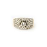 A gold and diamond set ring, in a bombe cluster design,