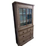 An early 19th century painted pine housekeeper's cupboard with glazed upper doors over drawers,