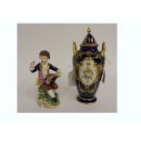 A Derby porcelain figure of a young boy seated with fruit filled hat, 13cm high,