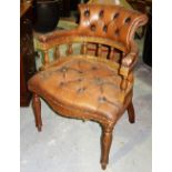 A 20th century mahogany and brown leather button upholstered desk chair.